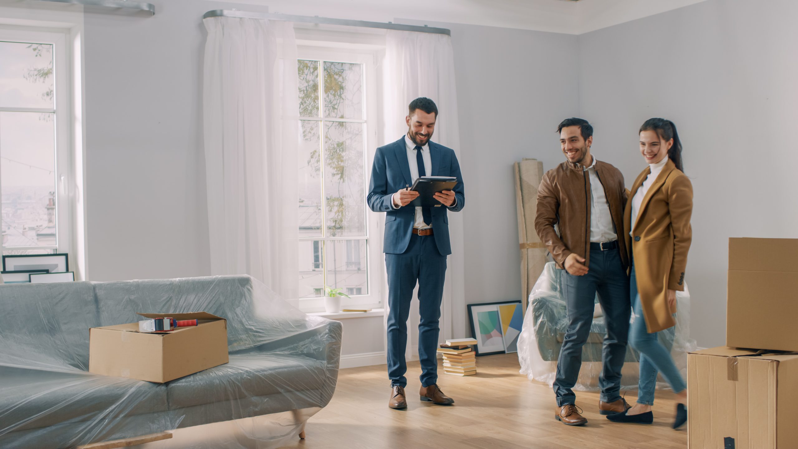 real estate agent showing new apartment to young couple