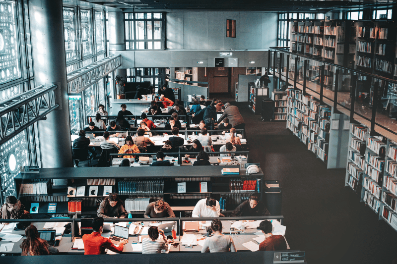 Students studying in a library, preparing for real estate exams.