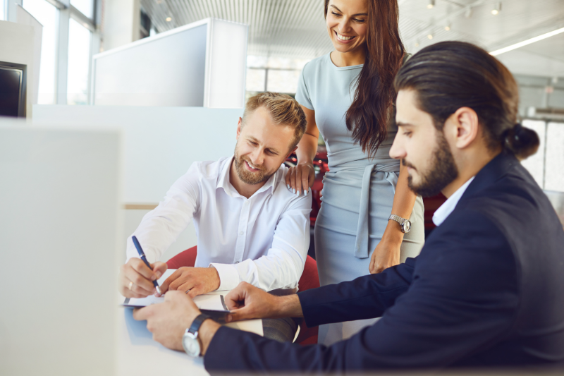 Real estate agent guiding clients as they sign a property agreement in a modern office